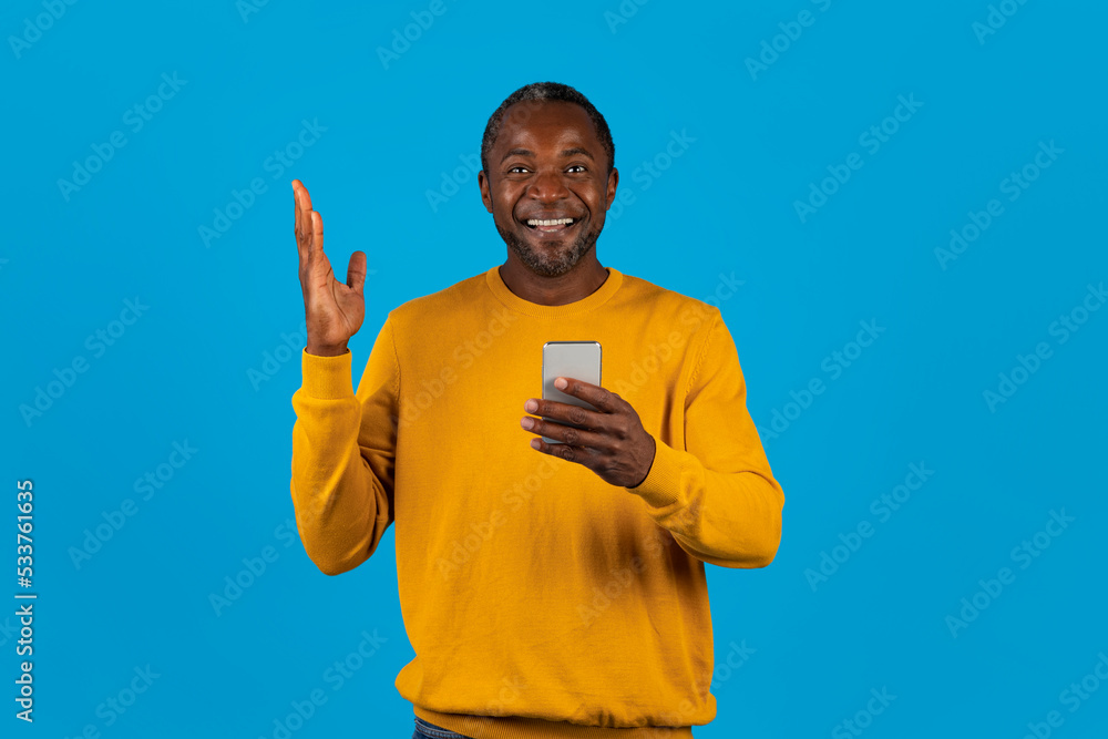 Excited african american man with cell phone gesturing Excited african american man with cell phone gesturing