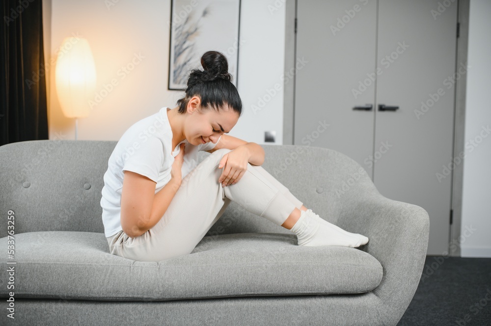 Young woman suffering from abdominal pain at home. Gynecology concept Young woman suffering from abdominal pain at home. Gynecology concept