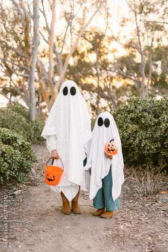 Children wearing ghost costume with pumpkin