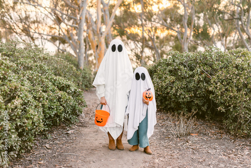 Children wearing ghost costume with pumpkin