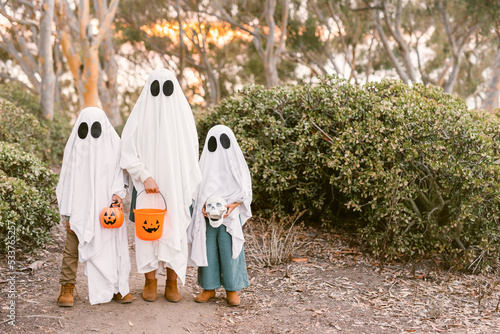 Children wearing ghost costume with pumpkin