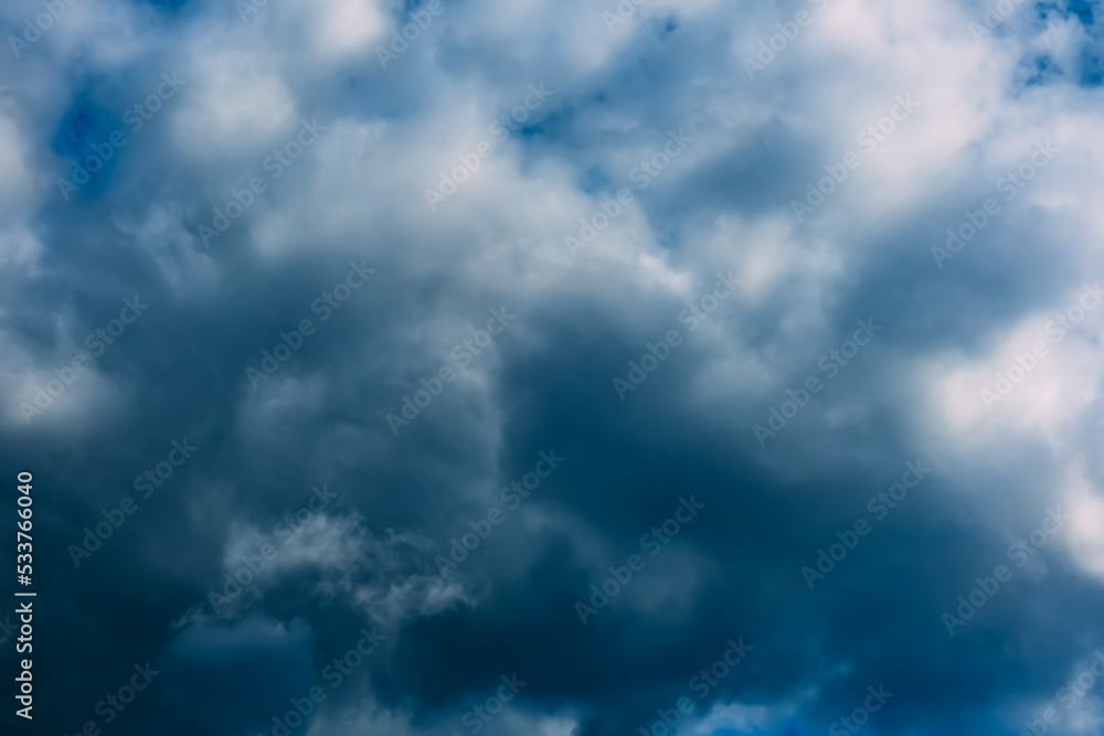 A dark blue cloudy sky. Cumulus clouds. Nature background. Bad weather forecast. Before a thunderstorm, hurricane or storm. The power and strength of nature. Air element. Wallpaper. Moving ciclone