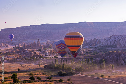 beautiful view of the flight of hot air balloons in the early morning in the valley of Goreme Cappadocia against the sun