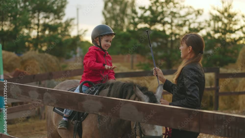 child is training with equestrian instructor in pony club, riding horse and exercising with sticks child is training with equestrian instructor in pony club, riding horse and exercising with sticks