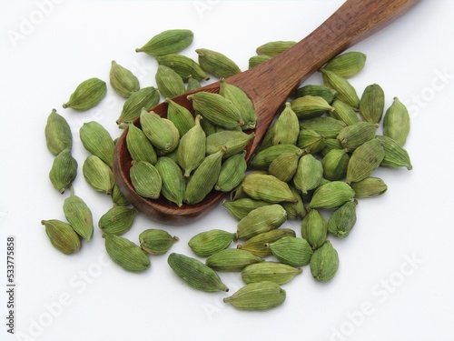 Green cardamom on a wooden spoon 