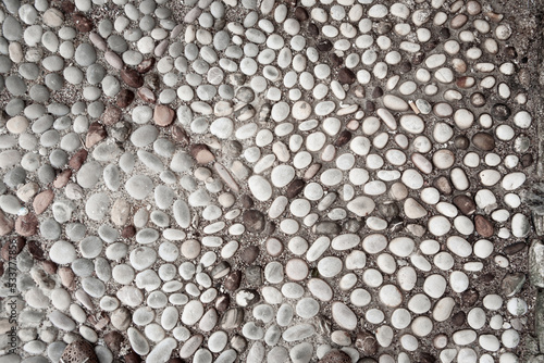 Decorative background of small pebbles. Pattern made of pebbles in the concrete mixture for poster, branding, calendar, card, banner, cover, space for your design or text. High quality photo
