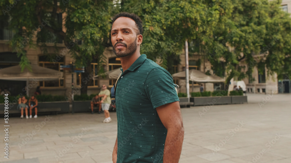 Young man tourist walks along the square of the old city, considers the sights Young man tourist walks along the square of the old city, considers the sights
