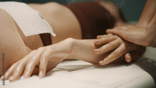 Lymphatic drainage massage in spa salon. Massage therapist massages client's hands and, pressing with palms, glides over hand to disperse lymph. Relaxation and enjoyment. Healthy Lifestyle. Body care