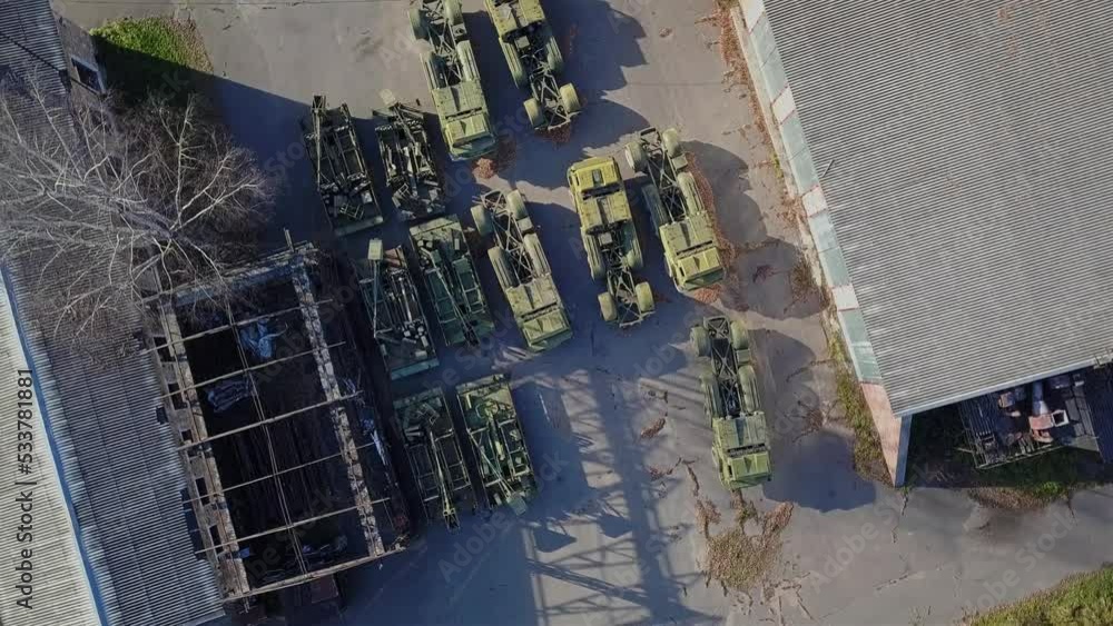 Aerial view of military equipment that stands on a concrete platform. The camera smoothly moves away from the ground when shooting Aerial view of military equipment that stands on a concrete platform. The camera smoothly moves away from the ground when shooting