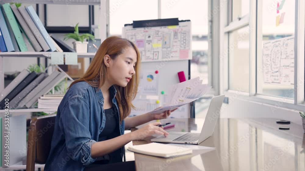 Young Asian female entrepreneur working from home while using a laptop Young Asian female entrepreneur working from home while using a laptop
