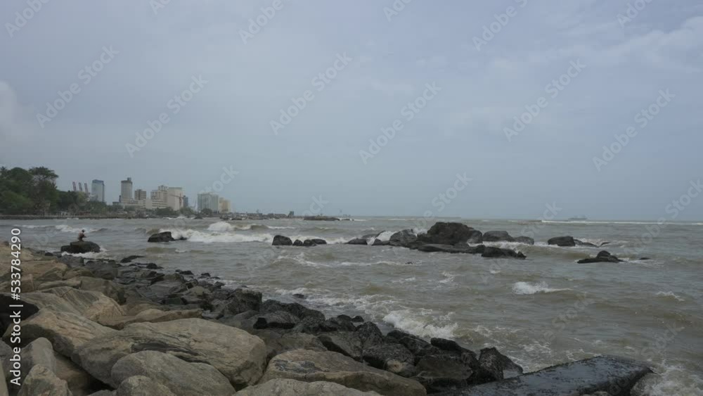 Gorgeous sea view of the ocean waves surge and break into the rocky shoreline at Colombo, Sri Lanka