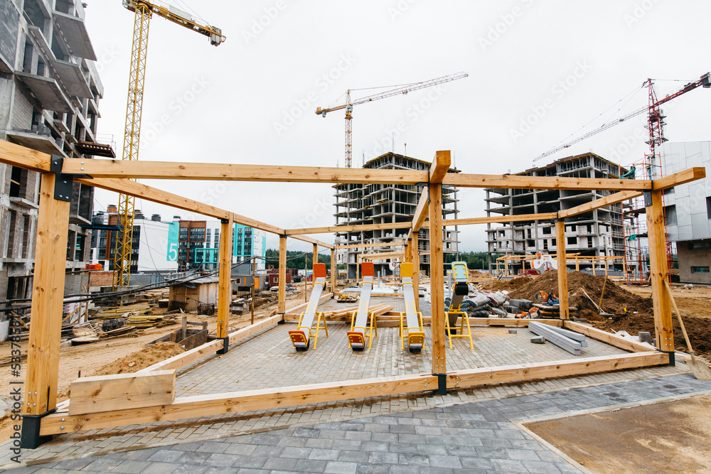 children's swing against the backdrop of a construction site in a residential area children's swing against the backdrop of a construction site in a residential area