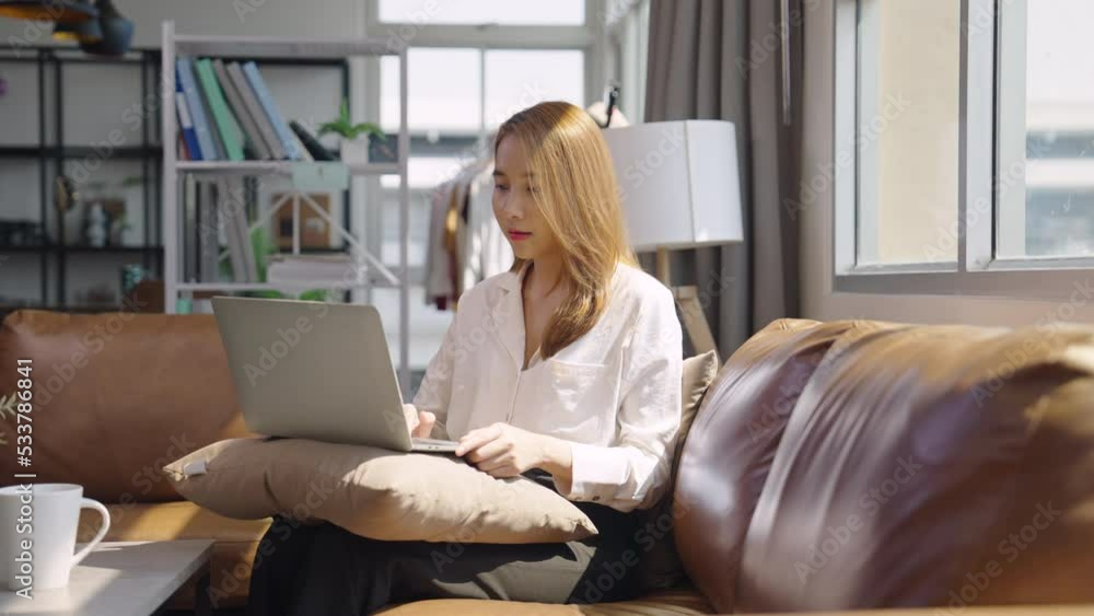 Young Asian female entrepreneur working from home while using a laptop Young Asian female entrepreneur working from home while using a laptop