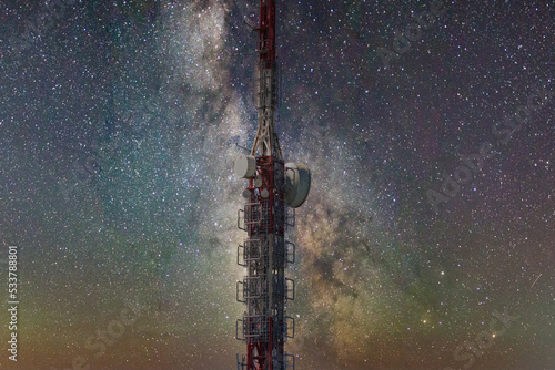 Foto nocturna de una torre de telecomunicaciones delante de una galaxia photo