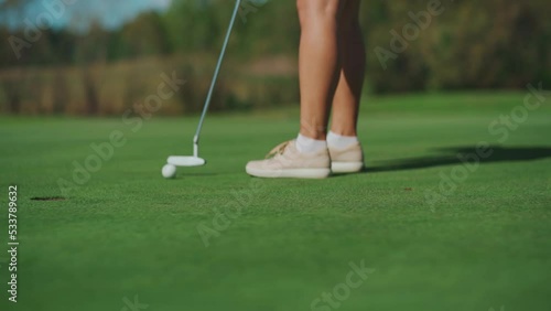 While playing golf, a girl hits the ball with a club and it hits the hole