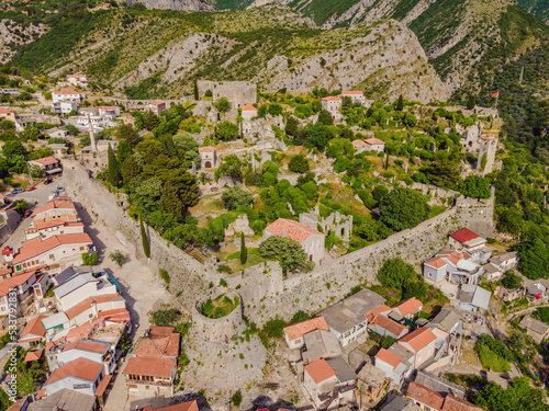 Old city. Sunny view of ruins of citadel in Stari Bar town near Bar city, Montenegro. Drone view Portrait of a disgruntled girl sitting at a cafe table