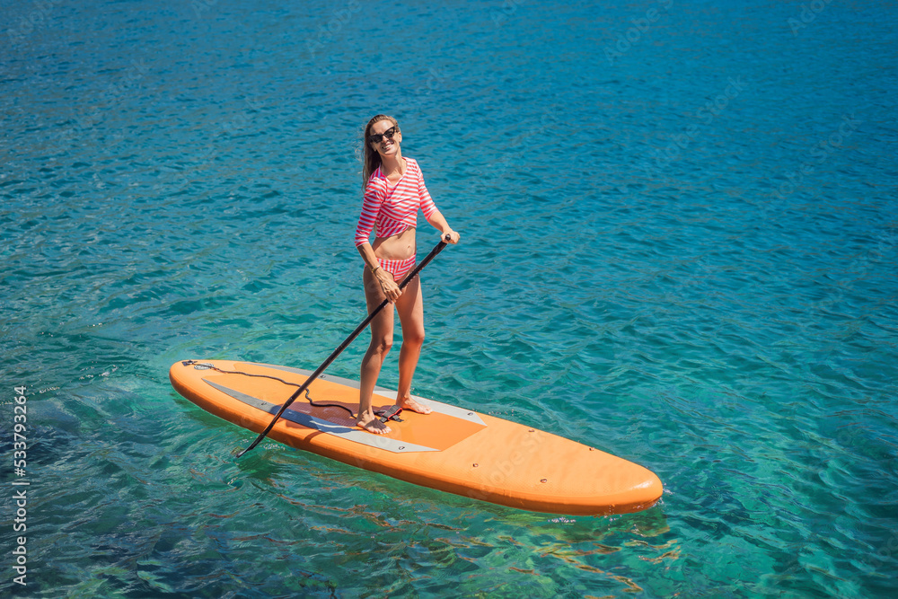 Young women Having Fun Stand Up Paddling in blue water sea in Montenegro. SUP. girl Training on Paddle Board near the rocks Portrait of a disgruntled girl sitting at a cafe table Young women Having Fun Stand Up Paddling in blue water sea in Montenegro. SUP. girl Training on Paddle Board near the rocks Portrait of a disgruntled girl sitting at a cafe table