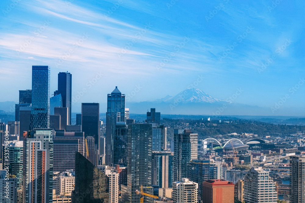 Panoramic Seattle financial district skyline in city downtown with Mount Rainier in the background.