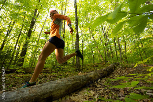 woman running in a sunny spring green forest photo