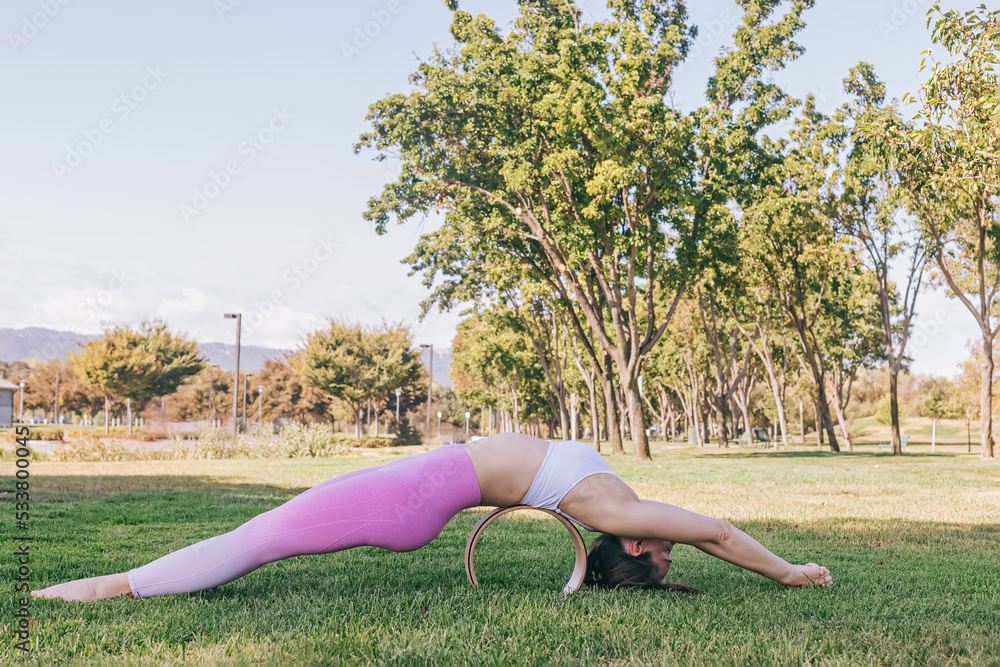 Fototapeta premium Fit young woman practicing yoga in the park.