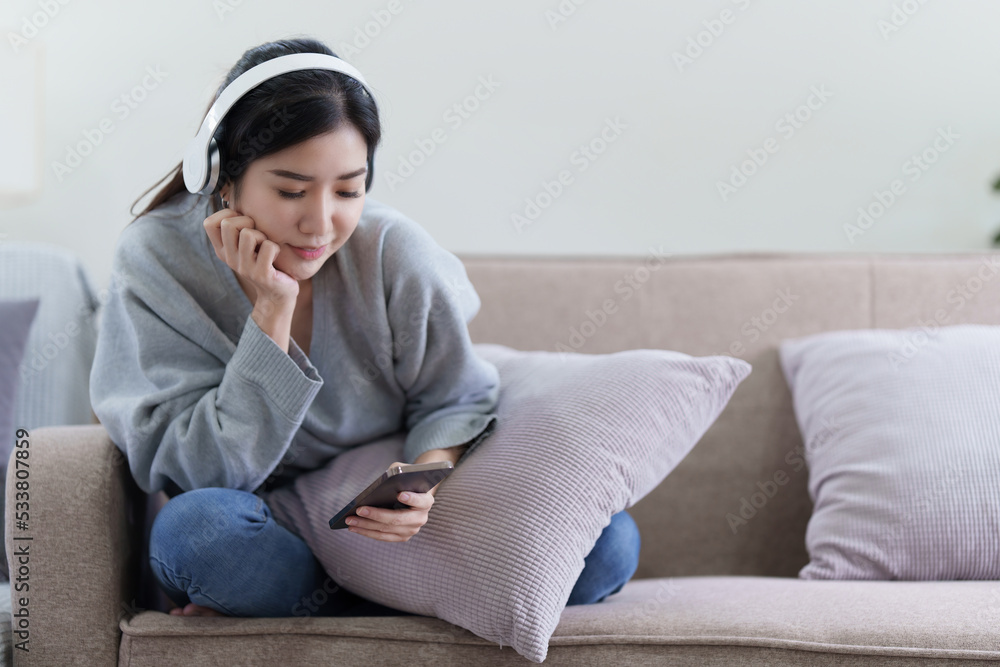 Asian woman checking social media by phone and listen music. lifestyle concept Asian woman checking social media by phone and listen music. lifestyle concept