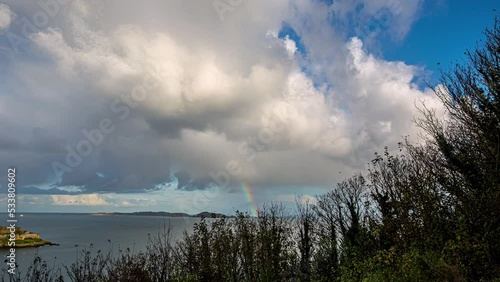 Time lapse of rainbow appearing in the clouds over the sea photo