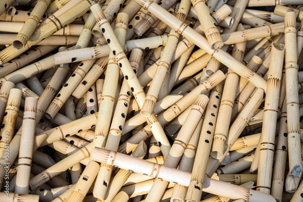 Pile of half-finished bamboo flutes, handmade bamboo flute production process by craftsmen, bamboo flutes being dried before finishing and marketed Pile of half-finished bamboo flutes, handmade bamboo flute production process by craftsmen, bamboo flutes being dried before finishing and marketed
