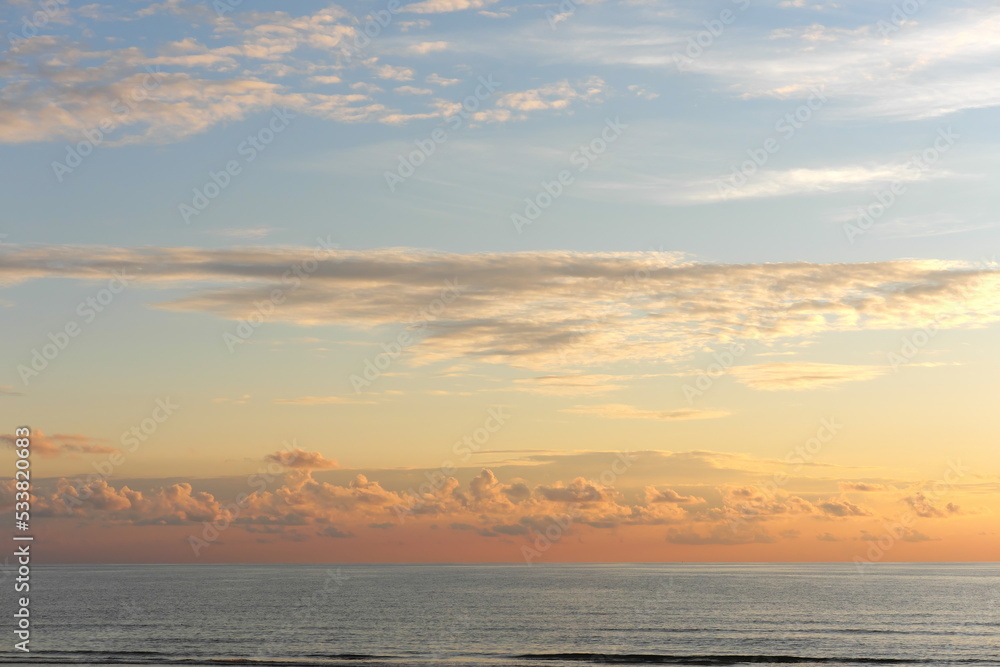 Seascape with beautiful evening sky. Sunset over a calm sea, pastel colors.