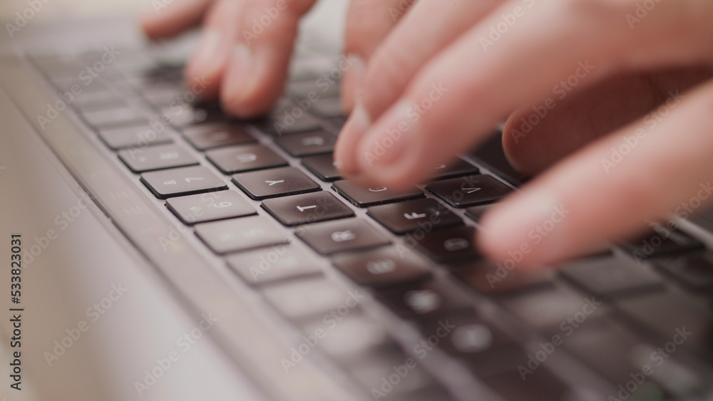Close up macro of hands typing on laptop keyboard mac computer