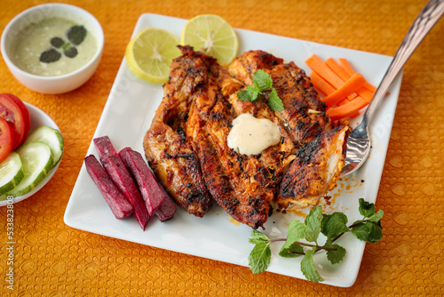 Thandoori chicken , Arabian spicy food tandoori whole chicken Bengaluru, India . Platter served with salads. Al Faham Charcoal Grilled Chicken in India .