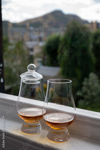 Two glasses of single malt scotch whisky served on old window sill in Scottisch house with view on old part of Edinburgh, Scotland, UK © barmalini