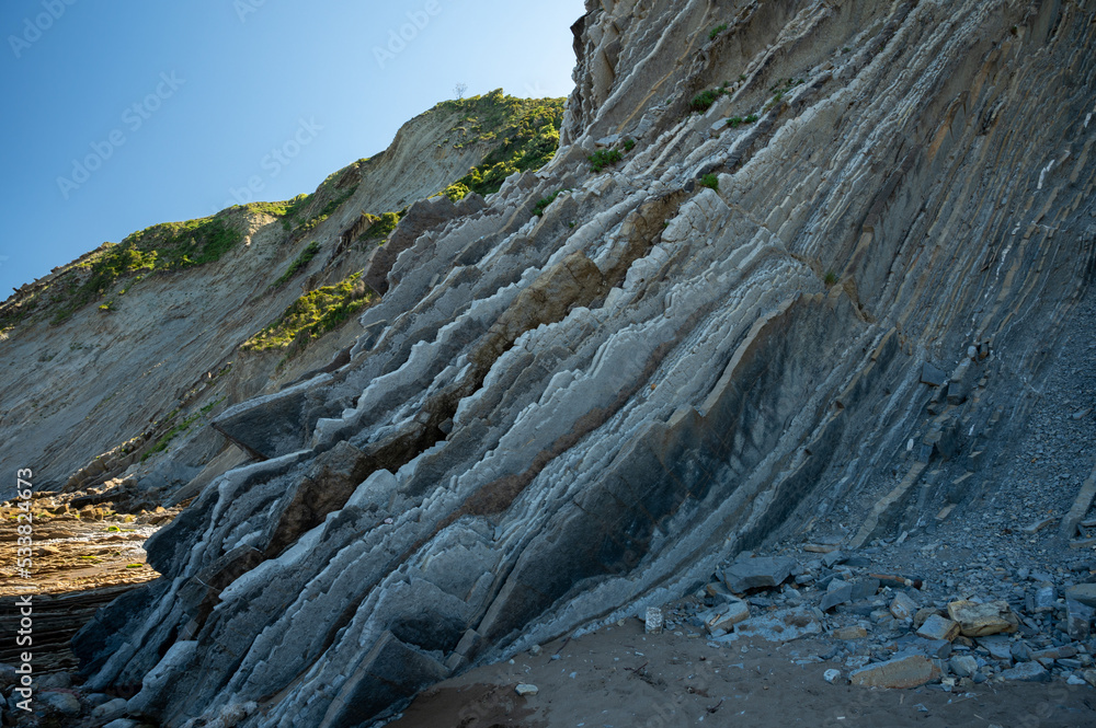 View on steeply-tilted layers of flysch on Atlantic coast at Zumaia at low tide, Basque Country, Spain View on steeply-tilted layers of flysch on Atlantic coast at Zumaia at low tide, Basque Country, Spain