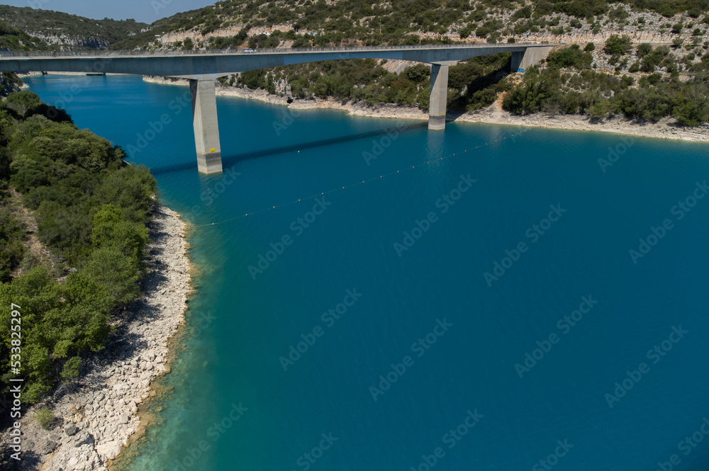Aerial view on blue lake Sainte-Croix-du-Verdon, road bridge and cliffs, tourists destination in France Aerial view on blue lake Sainte-Croix-du-Verdon, road bridge and cliffs, tourists destination in France
