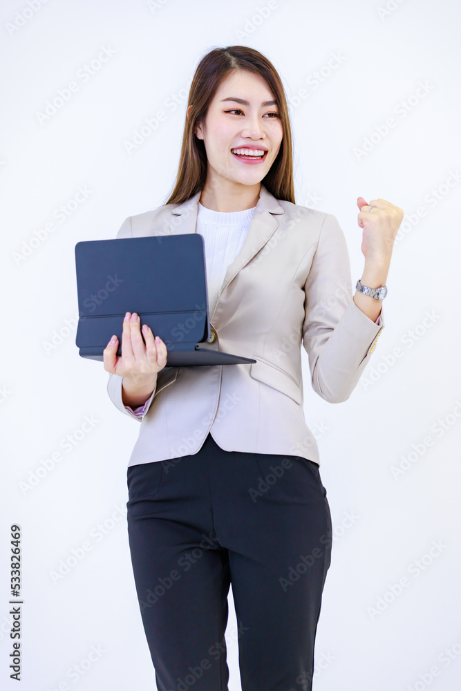 Isolated cutout studio shot of Millennial Asian professional successful happy businesswoman model in formal suit holding tablet computer fist up screaming celebrating victory on white background Isolated cutout studio shot of Millennial Asian professional successful happy businesswoman model in formal suit holding tablet computer fist up screaming celebrating victory on white background