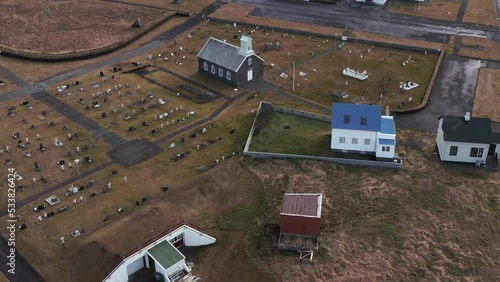 Historic graveyard with church revealing residential neighborhood in Iceland, aerial photo