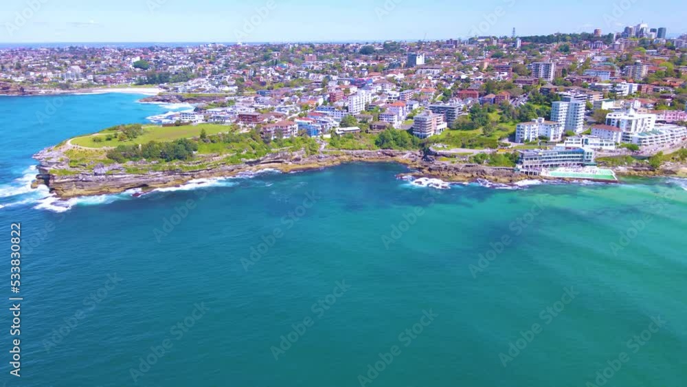 Aerial drone view of iconic Bondi Beach in Sydney, Australia heading toward Bondi Beach pool on a sunny day during spring 2022 Aerial drone view of iconic Bondi Beach in Sydney, Australia heading toward Bondi Beach pool on a sunny day during spring 2022