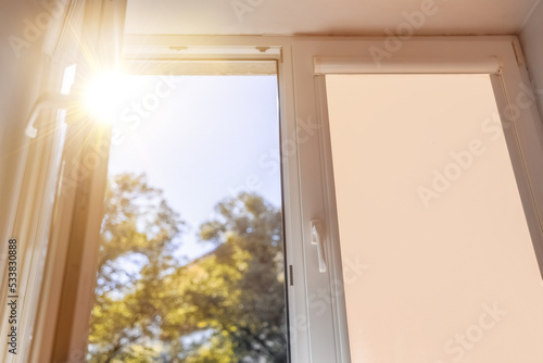 open white plastic window overlooking nature on a summer sunny day. © Marina Gordejeva