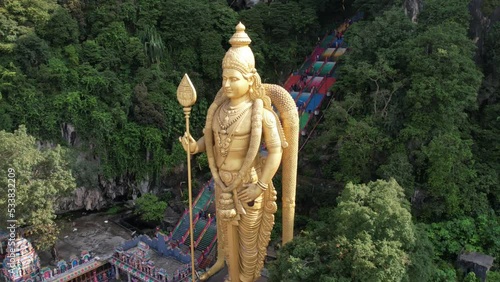 Drone takes rotating hyperlapse of Lord Murugan statue in Batu Caves at Kualar Lumpur, Malaysia which is located in the limestone hill  photo