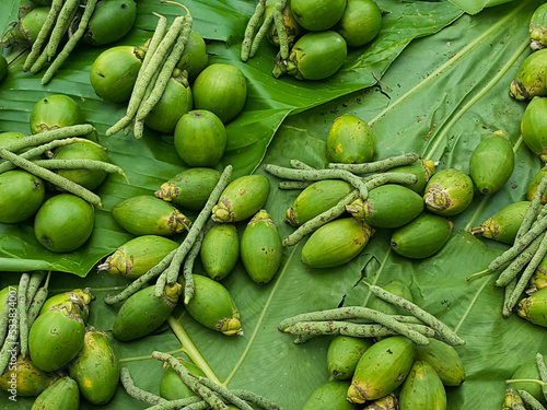 Areca nut, called buai and betel nut on the tropical island of Bougainville, Papua New Guinea, displayed on palm leaves at a local fruit and vegetable market