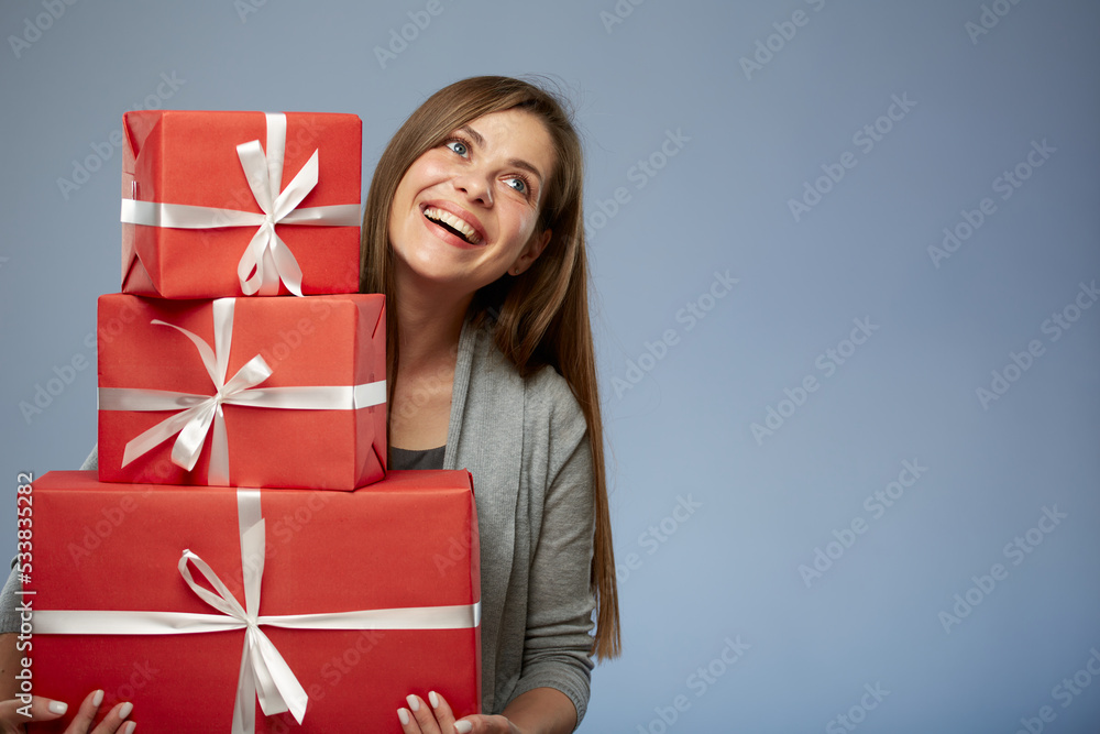 Happy woman holding stack of presents looking away. Isolated female portrait. Girl celebrate Christmas or some thing more. Happy woman holding stack of presents looking away. Isolated female portrait. Girl celebrate Christmas or some thing more.