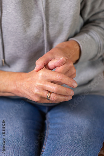 Senior woman suffering from hand and finger joint pain, inflammation