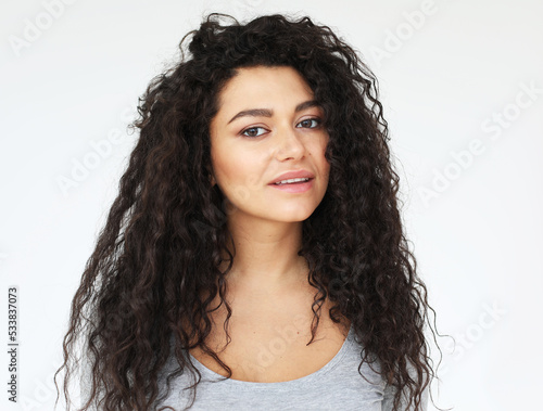 young smiling woman with long curly haor wearing casual shirt, feel happy and smiling photo