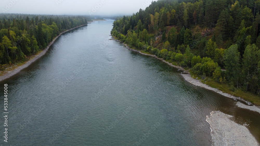 Wild nature landscape drone view with river and forest. Fog above water. Mountain Siberian river flow, water on stones,  forest  trees. aero view.