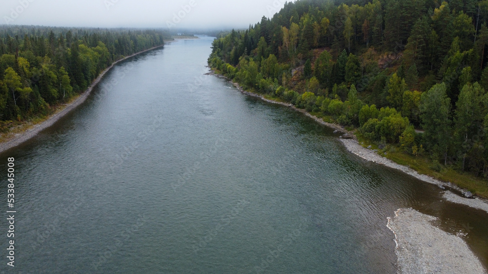 Wild nature landscape drone view with river and forest. Fog above water. Mountain Siberian river flow, water on stones, forest trees. aero view. Wild nature landscape drone view with river and forest. Fog above water. Mountain Siberian river flow, water on stones, forest trees. aero view.