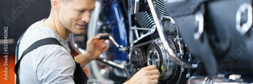 Qualified handyman with tool fix damaged motorbike in garage