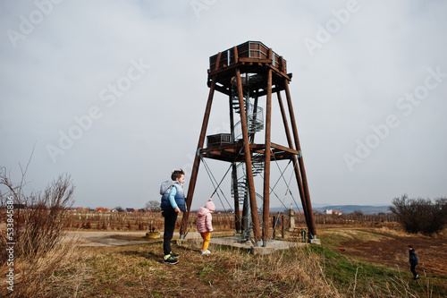 Children against wooden observation tower.