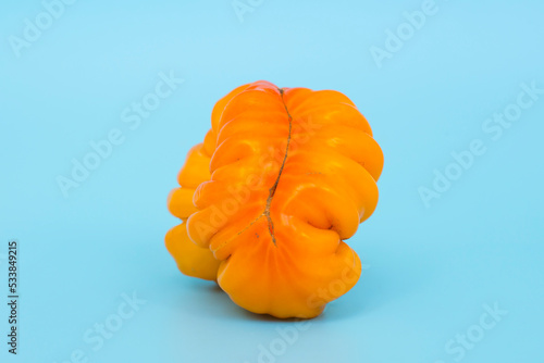 Ugly vegetables concept. Tomatoes of various unusual shapes on a blue minimal background. A metaphor for imperfection, the female body, the art of photography and form. photo