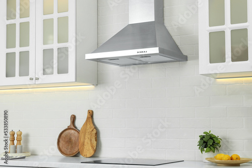 фотографія Elegant kitchen interior with modern range hood over cooktop and stylish furnitu