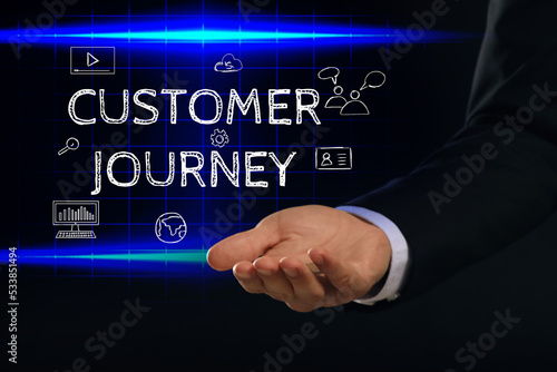 Customer journey concept. Man demonstration phrase and different icons on virtual screen against dark background, closeup