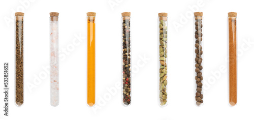 Set of glass tubes with different spices on white background, top view. Banner design